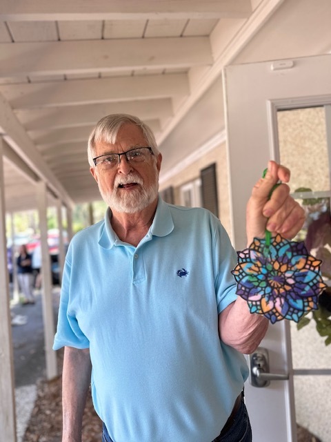 A participant showing his stained-glass craft